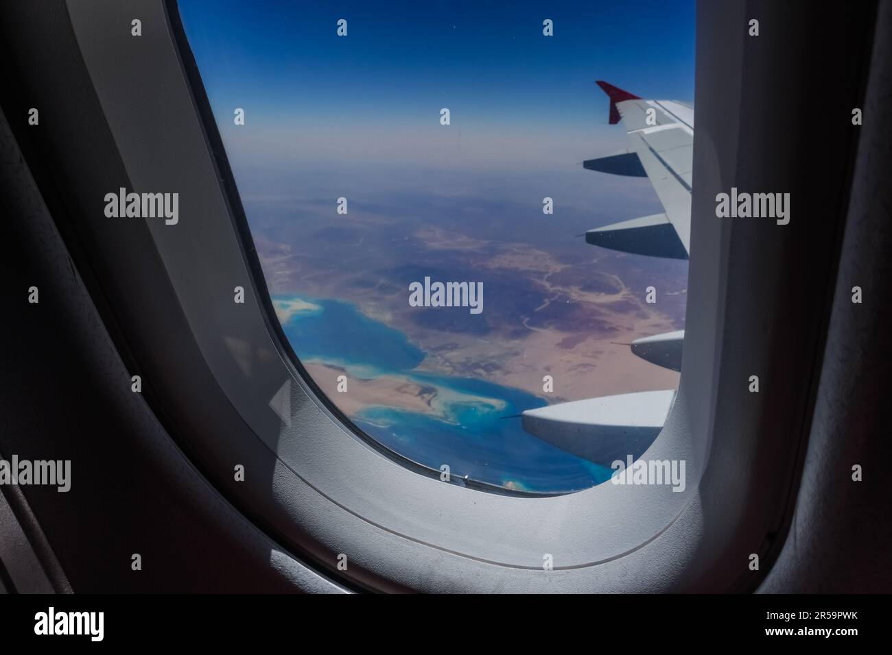 vista attraverso la finestra da un aereo durante un volo sul deserto con il mare rosso in egitto Foto Stock