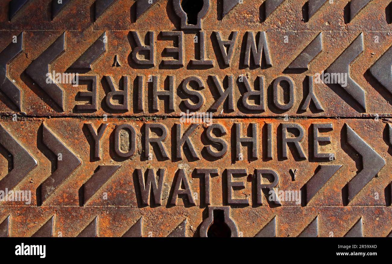 Primo piano di una rete pubblica in ghisa arrugginita con la scritta “Yorkshire Water”, che illustra le infrastrutture idriche pubbliche e l’invecchiamento della lavorazione dei metalli Foto Stock