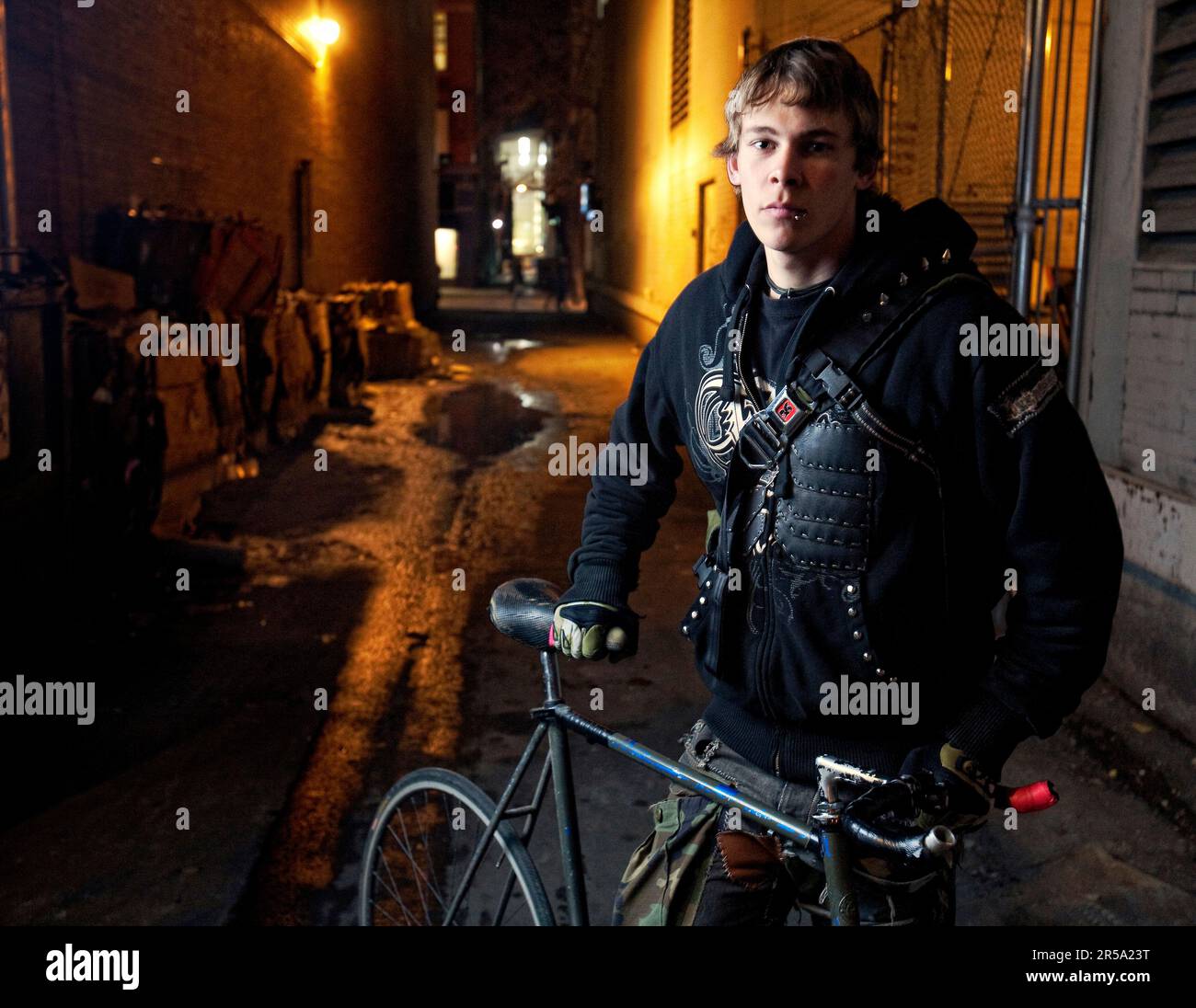 Fixed Gear Rider si pone in un alleato buio con la sua moto. Foto Stock