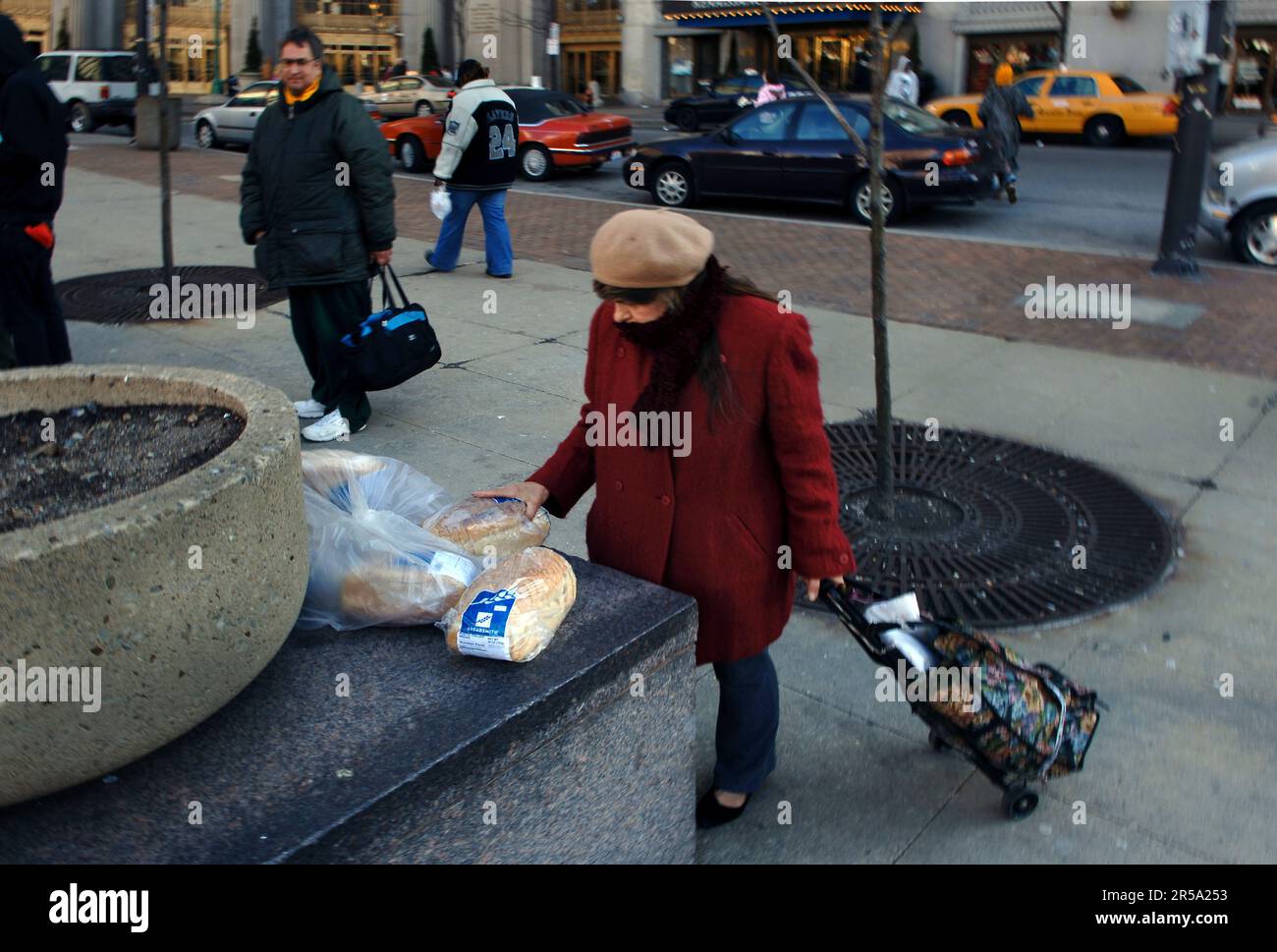 Questa donna sta smettendo di raccogliere il pane libero che ha un giorno. Foto Stock
