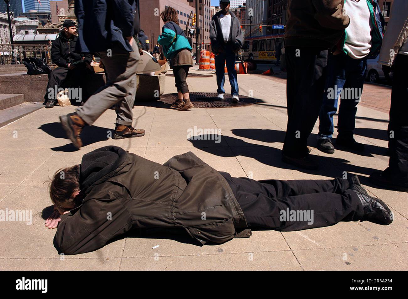 L'uomo senza casa prega sul marciapiede a Cleveland, Ohio. Foto Stock