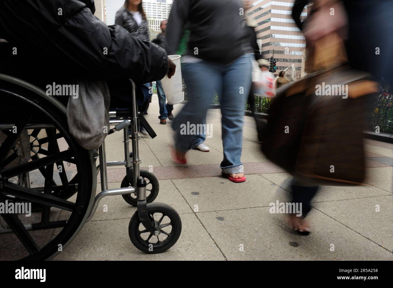 Un uomo senza casa che ha perso le gambe per il diabete chiede denaro ai pedoni su Michigan Ave. A Chicago. Foto Stock