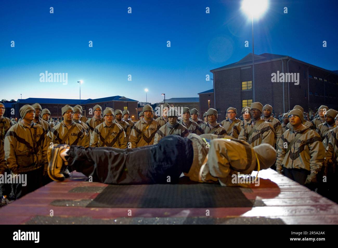 Un sergente di esercitazione mostra ai soldati nell'addestramento di base come fare correttamente una spinta in su durante la formazione fisica di addestramento. Foto Stock