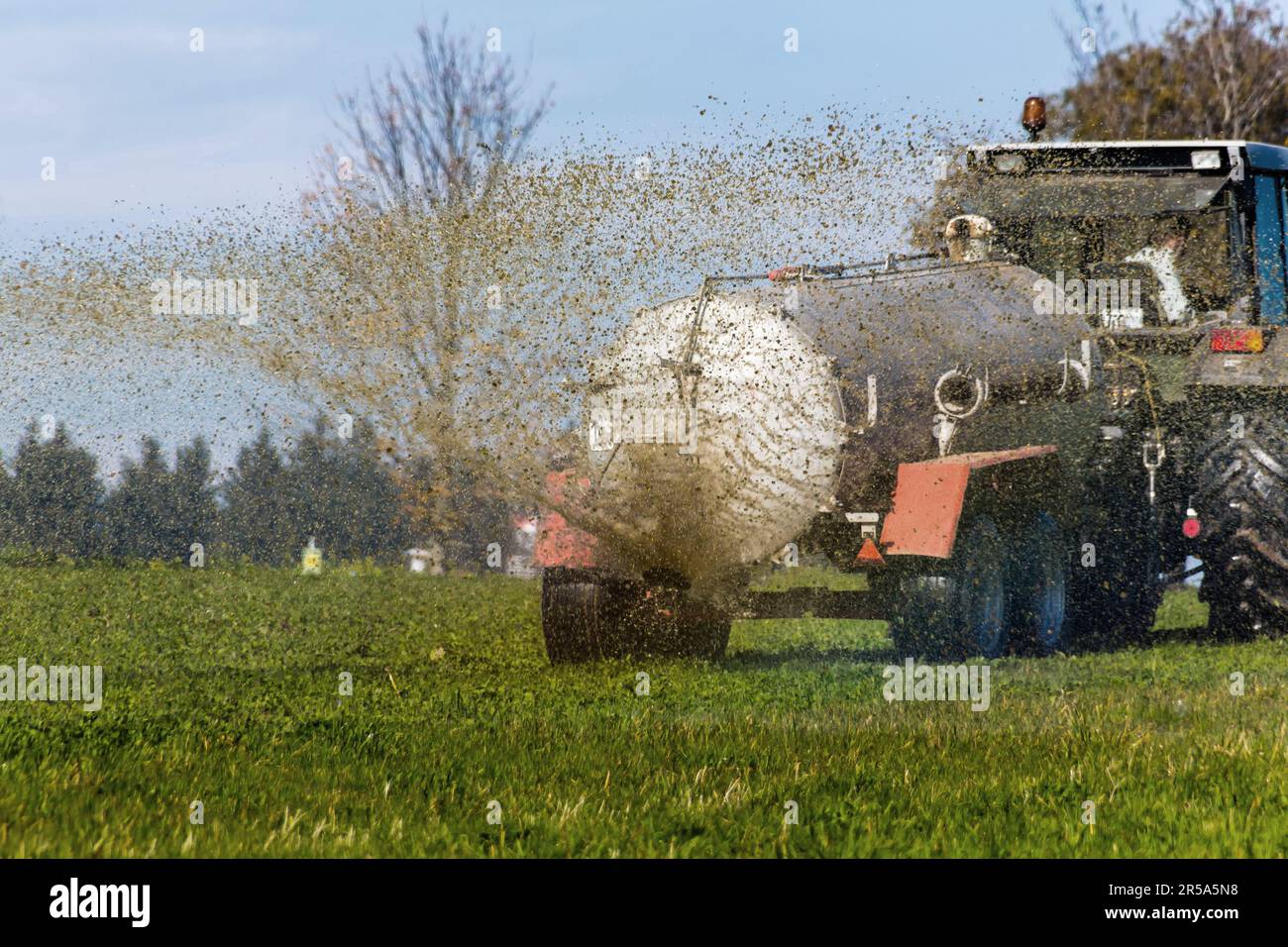 Un trattore che concima un campo con concime, Austria Foto Stock