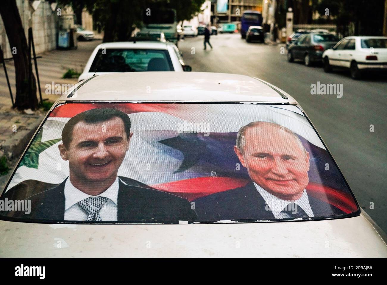 Grandi manifesti con ritratti del presidente siriano Bashar al-Assad e del presidente russo Vladimir Putin su un'auto a Damasco, Siria, 31.March 2023 --- Großplakate mit dem Konterfei des Präsidenten Baschar al-Assad und dem russischen Präsidenten Wladimir Putin an einem Auto a Damaskus, Syrien, 31.March 2023 Foto Stock