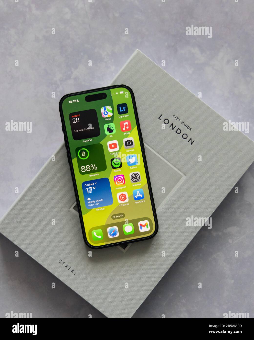 LONDRA - 28 MAGGIO 2023: Apple iPhone 14 Pro con icone dell'app per sfondi sulla schermata Home sfondo minimo per la configurazione della scrivania Foto Stock