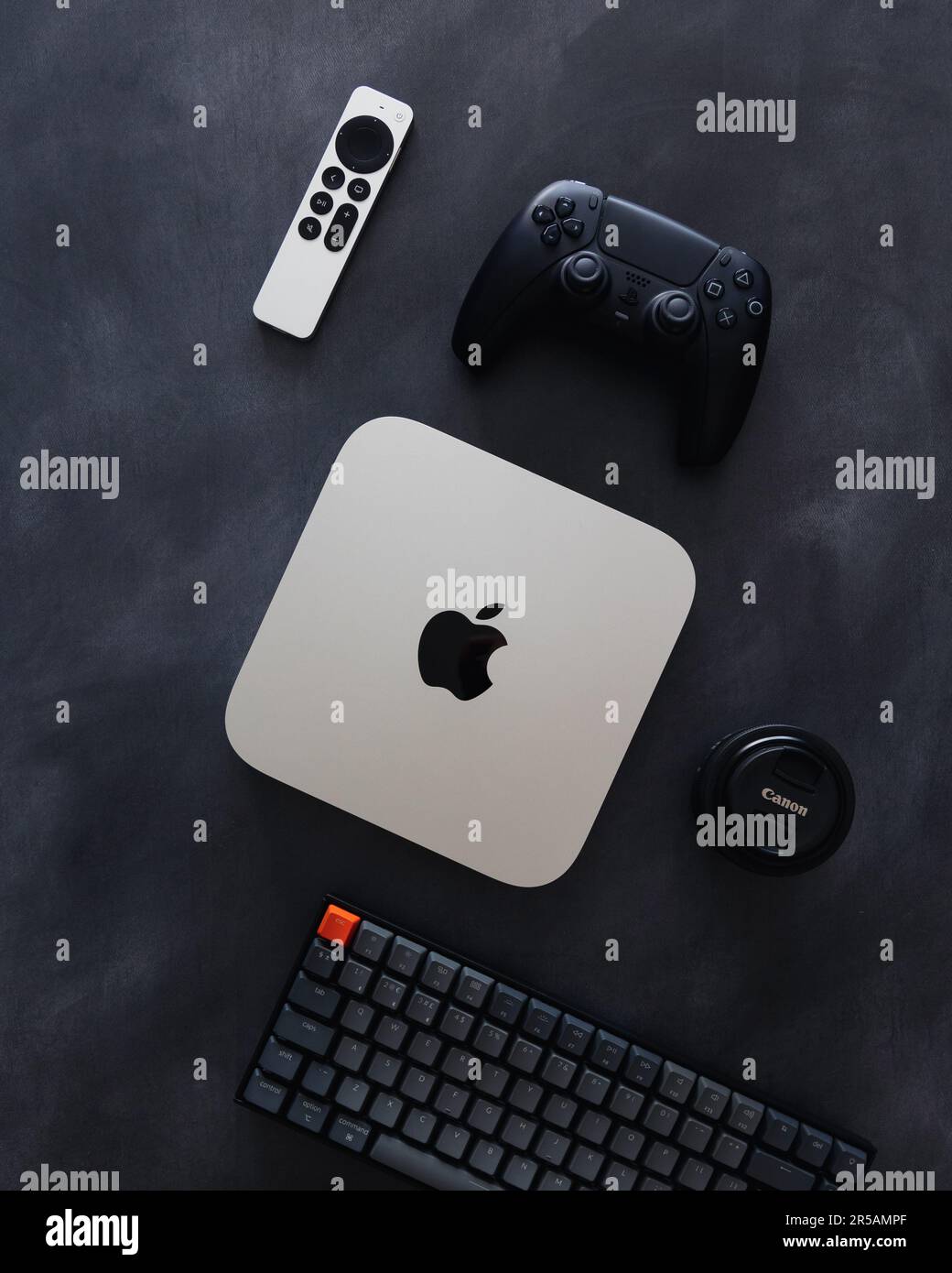 LONDRA - 21 MAGGIO 2023: Mini computer Apple Mac con logo vista dall'alto su sfondo scuro tecnologia flatlay configurazione minima della scrivania Foto Stock