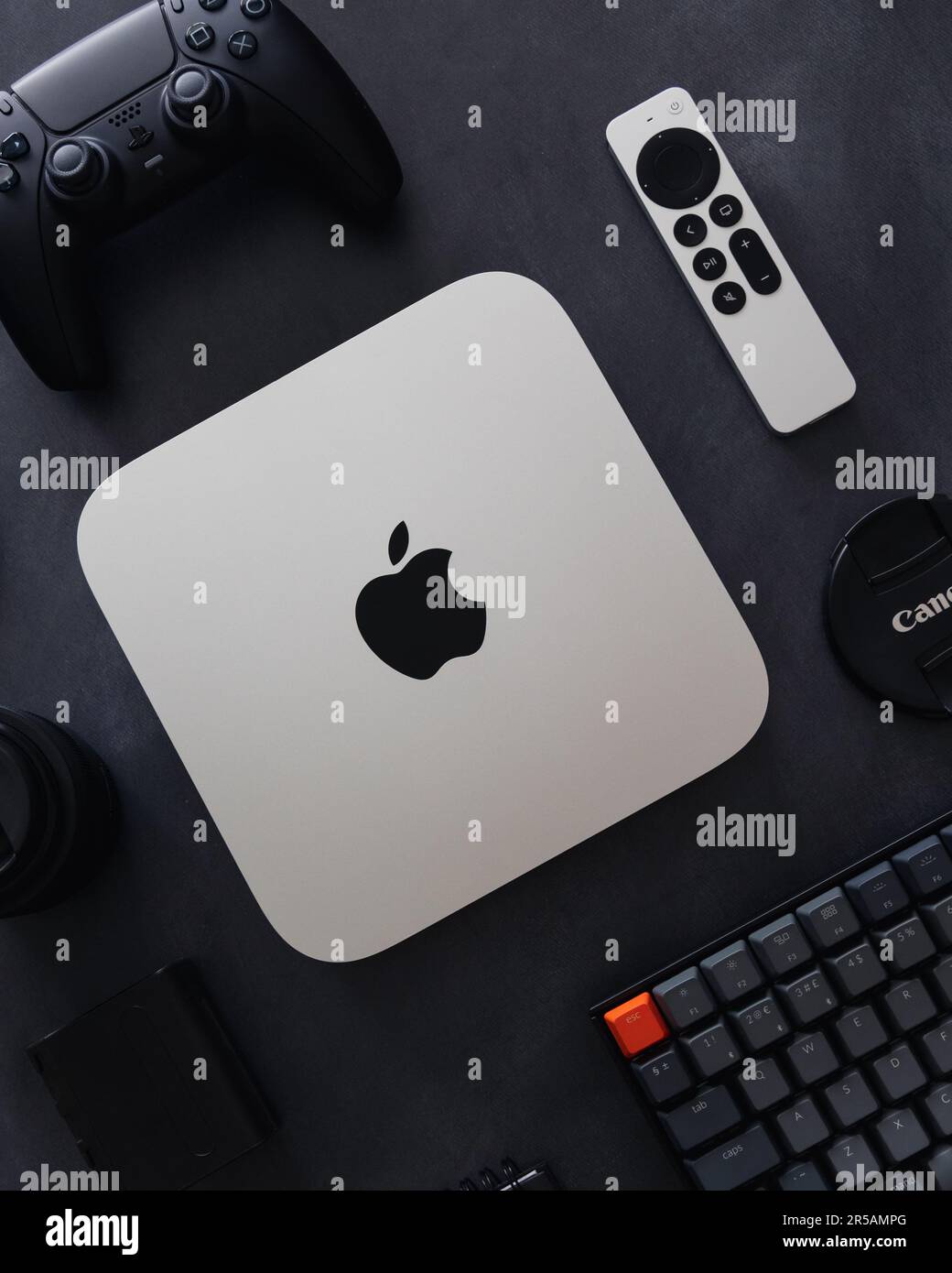 LONDRA - 21 MAGGIO 2023: Mini computer Apple Mac con logo vista dall'alto su sfondo scuro tecnologia flatlay configurazione minima della scrivania Foto Stock
