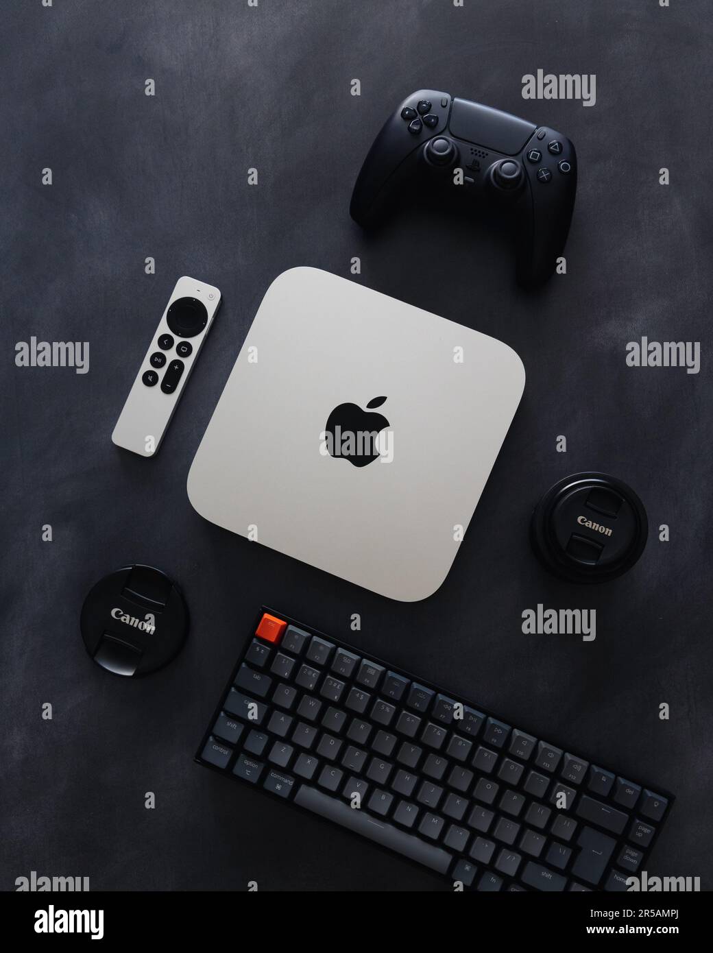 LONDRA - 21 MAGGIO 2023: Mini computer Apple Mac con logo vista dall'alto su sfondo scuro tecnologia flatlay configurazione minima della scrivania Foto Stock