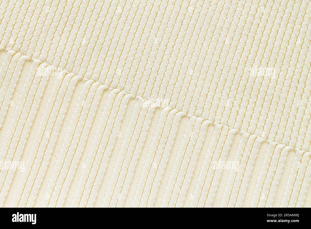 Sfondo testurizzato di tessuto beige lavorato a maglia in cotone o lana, primo piano Foto Stock