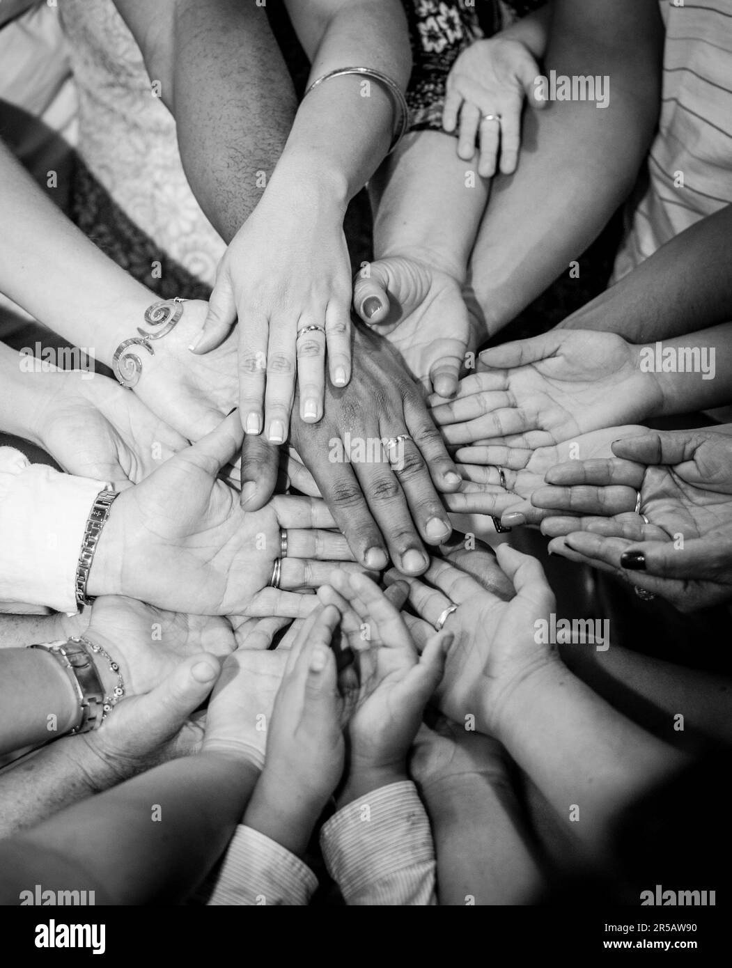 Gruppo di persone che mettono le mani insieme in un cerchio. Festa di famiglia. immagine in bianco e nero Foto Stock