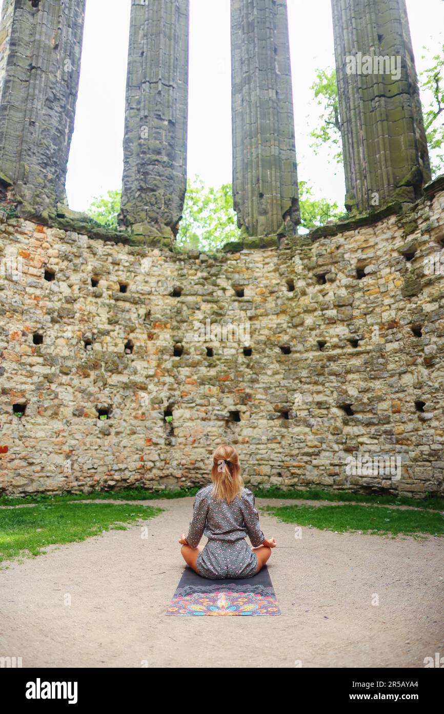 ragazza meditando nelle rovine di una vecchia chiesa Foto Stock