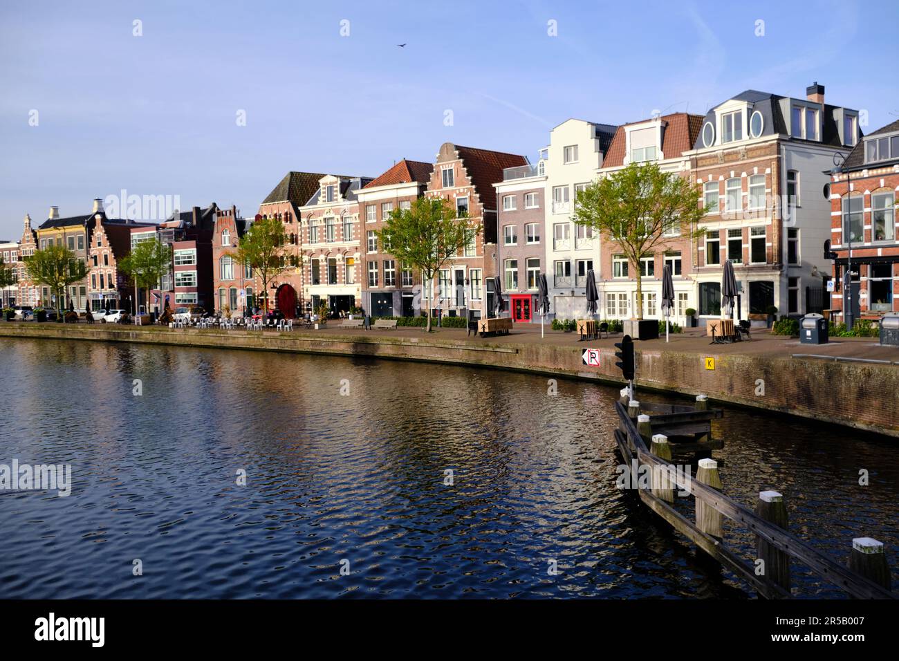 Haarlem, Paesi Bassi - Aprile 12. 2022: Case tradizionali olandesi che costeggiano il fiume Sparne visto dal ponte Melkbrug in primavera. Foto Stock