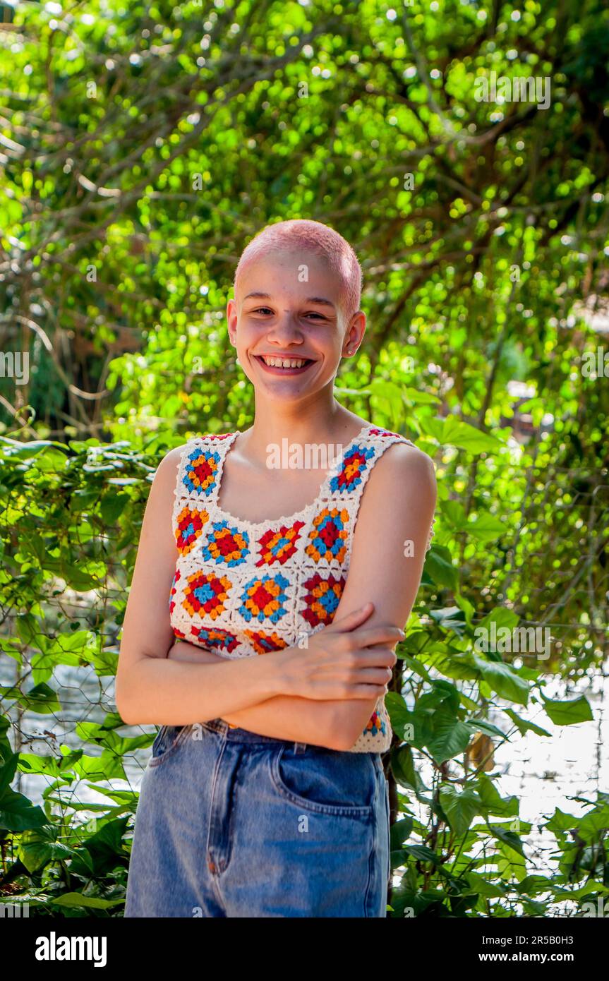 Ritratto di una ragazza con capelli molto corti, dipinto pink.Ritratto di ragazza che indossa abiti uncinetto. Foto Stock