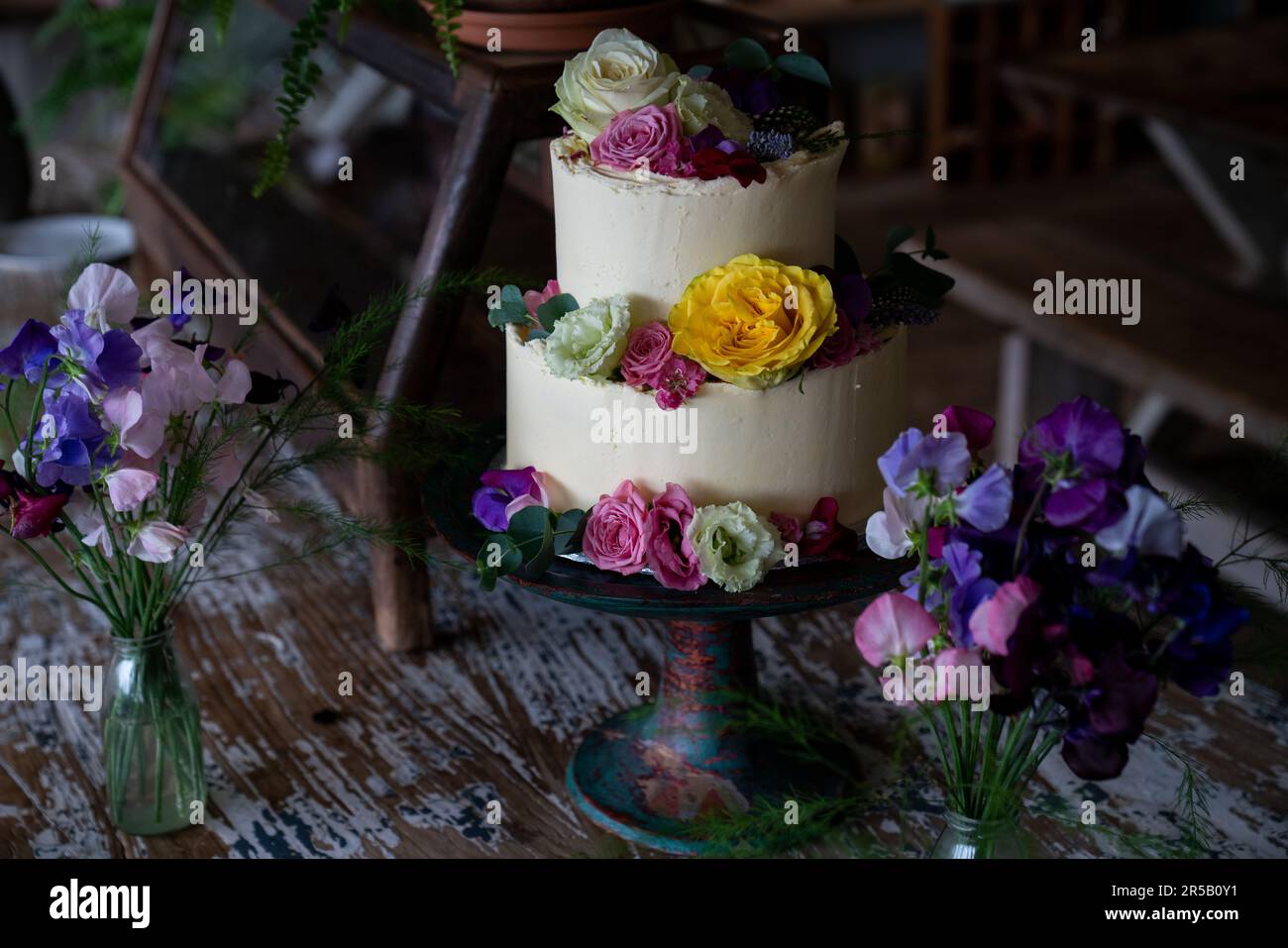 Torta nuziale decorata con fiori. Foto Stock