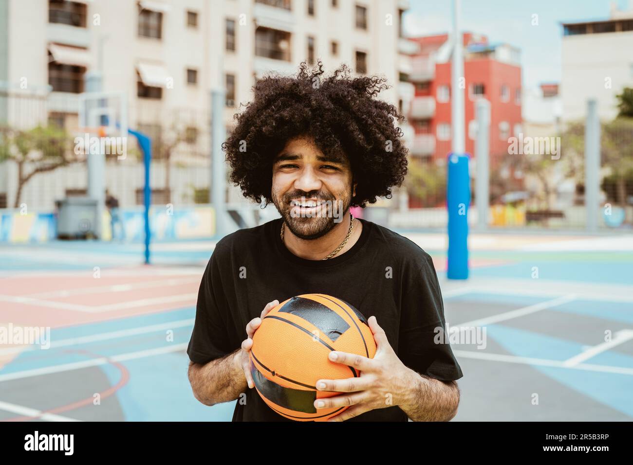 Uomo felice che gioca a basket all'aperto - concetto di stile di vita sportivo urbano Foto Stock