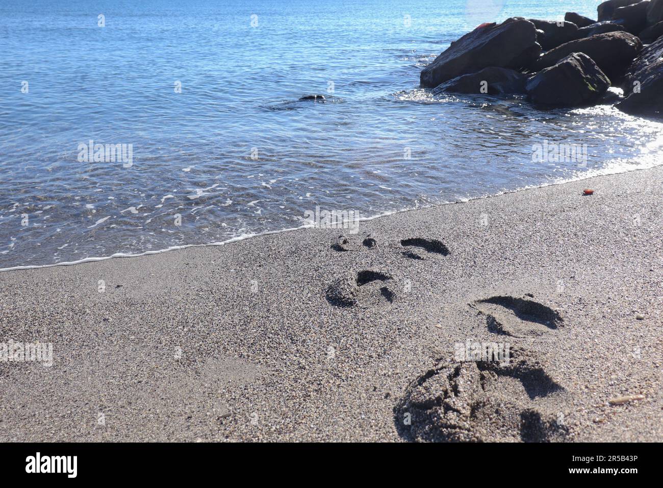 Impronte umane o gradini lasciati sulla sabbia di una spiaggia Foto Stock