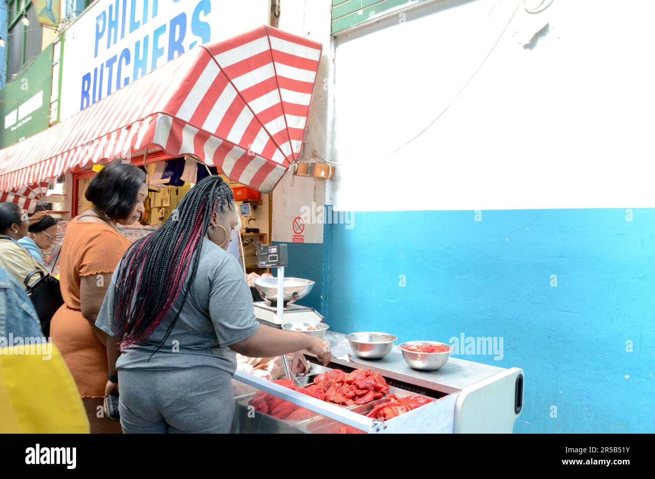 brixton SW9 mercato con bancarelle negozi ristoranti bar ecc in galleria e sulla strada a lambeth londra inghilterra gran bretagna; brixton villaggio mercato fila e brixton villaggio Foto Stock