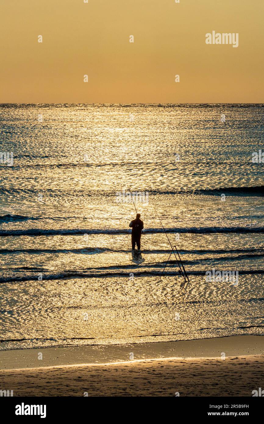 Beach casting per pescatori al tramonto, Whitesands Bay, una spiaggia con bandiera blu sulla penisola di St David nel Pembrokeshire Coast National Park, Galles occidentale Foto Stock