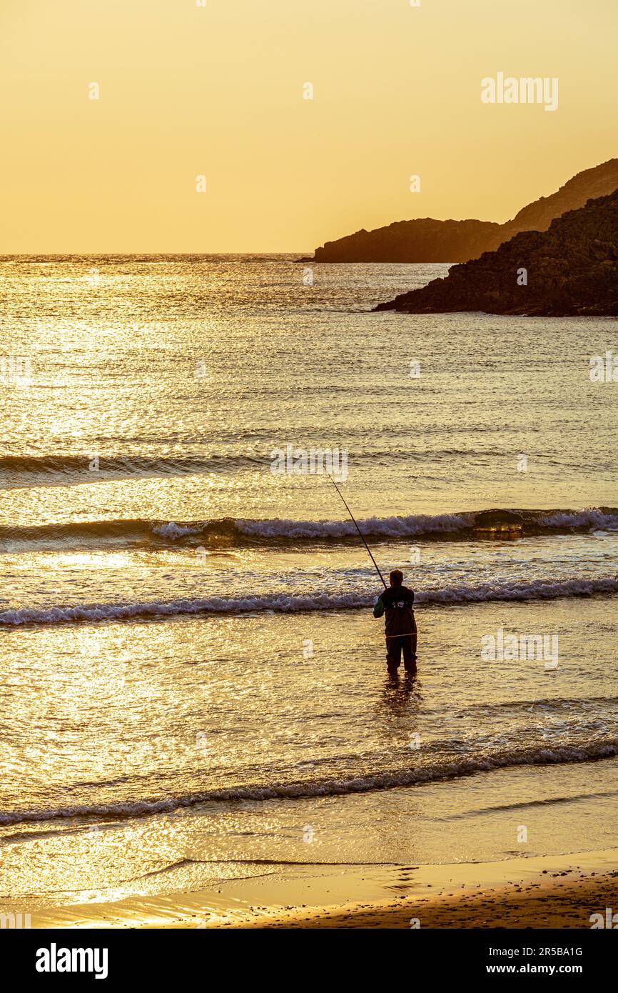 Beach casting per pescatori al tramonto, Whitesands Bay, una spiaggia con bandiera blu sulla penisola di St David nel Pembrokeshire Coast National Park, Galles occidentale Foto Stock