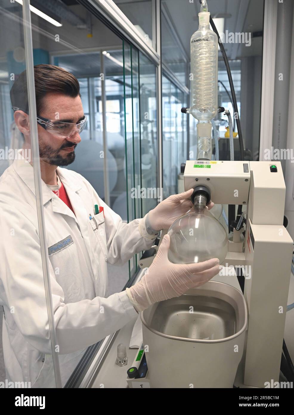 PRODUZIONE - 23 maggio 2023, Hesse, Darmstadt: Il tecnico di laboratorio chimico Florian Große utilizza un evaporatore rotante per preparare campioni per il controllo di qualità dei solventi per l'analisi ambientale in un laboratorio del gruppo farmaceutico e tecnologico Merck KGaA, con sede a Darmstadt. Il laboratorio di controllo qualità per solventi ad alta purezza nel settore Life Science di Merck verifica la qualità dei solventi da utilizzare nei laboratori di ricerca o nell'industria farmaceutica. Foto: Arne Dedert/dpa Foto Stock