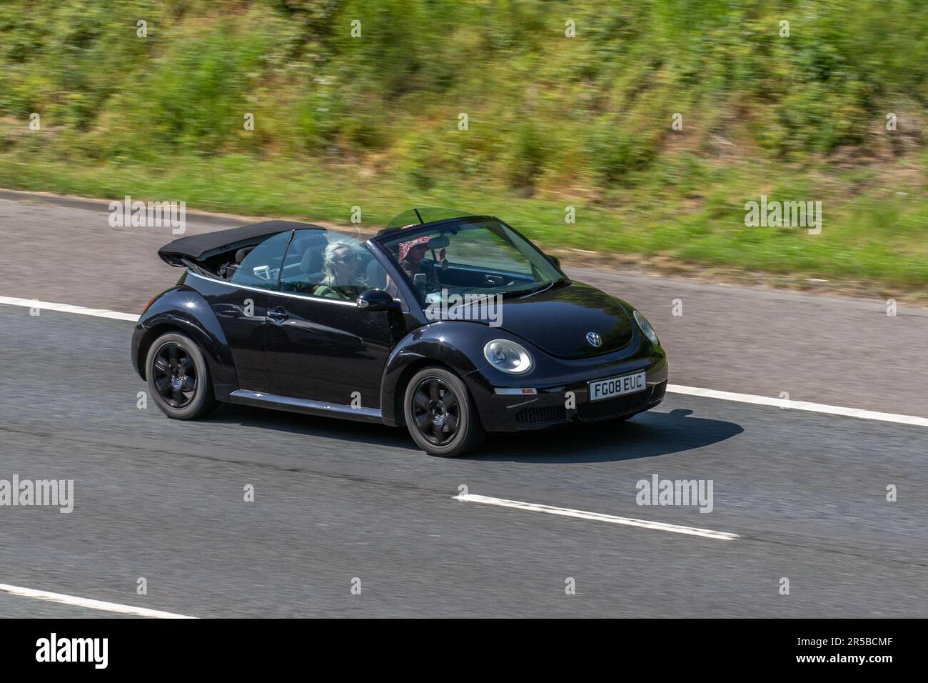 2008 Black Volkswagen Beetle Luna 102PS Cabrio; viaggia a velocità sostenuta sull'autostrada M6 a Greater Manchester, Regno Unito Foto Stock