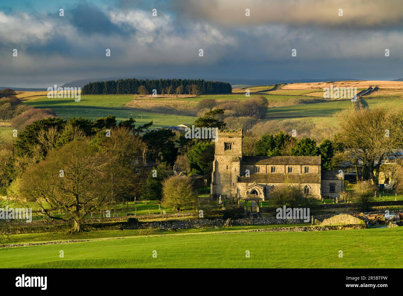 Bella vista sulla vecchia chiesa in pietra (villaggio rurale di Dales, luce serale e luce solare su terra e campi, brughiere di altipiano) - Rylstone, North Yorkshire, Inghilterra UK Foto Stock