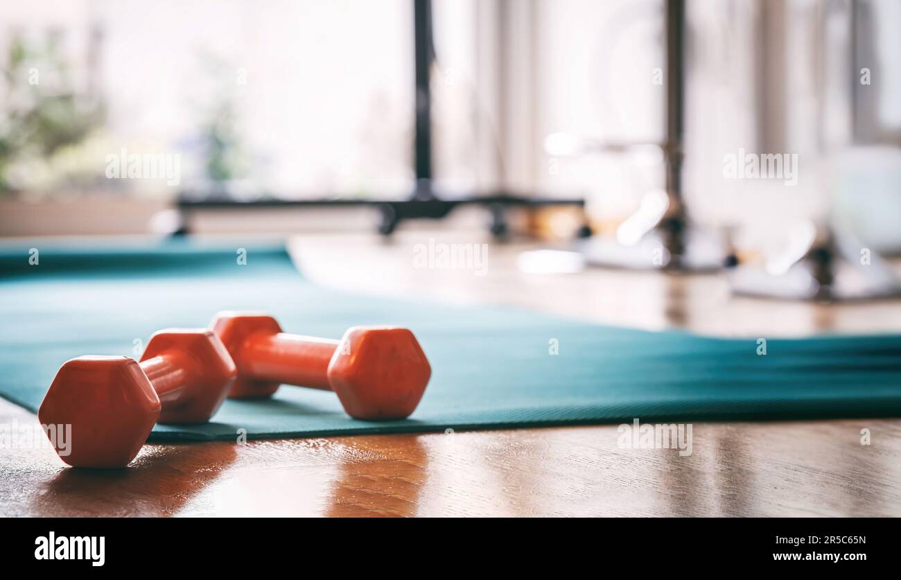 Manubri su un mat da ginnastica yoga closeup, interno palestra, allenamento e concetto di fitness Foto Stock