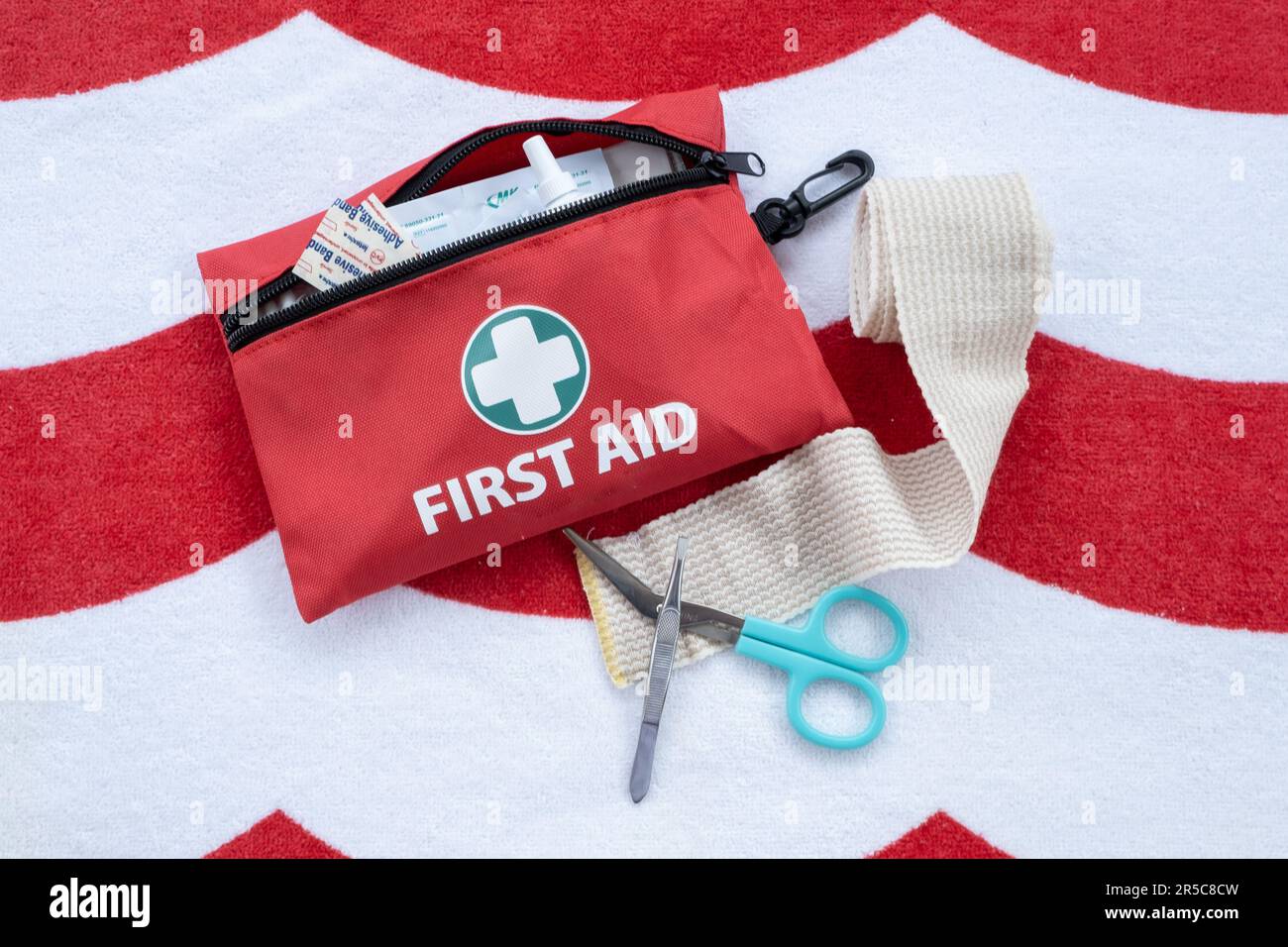 Kit medico di pronto soccorso e forniture su sfondo rosso e bianco. Foto Stock