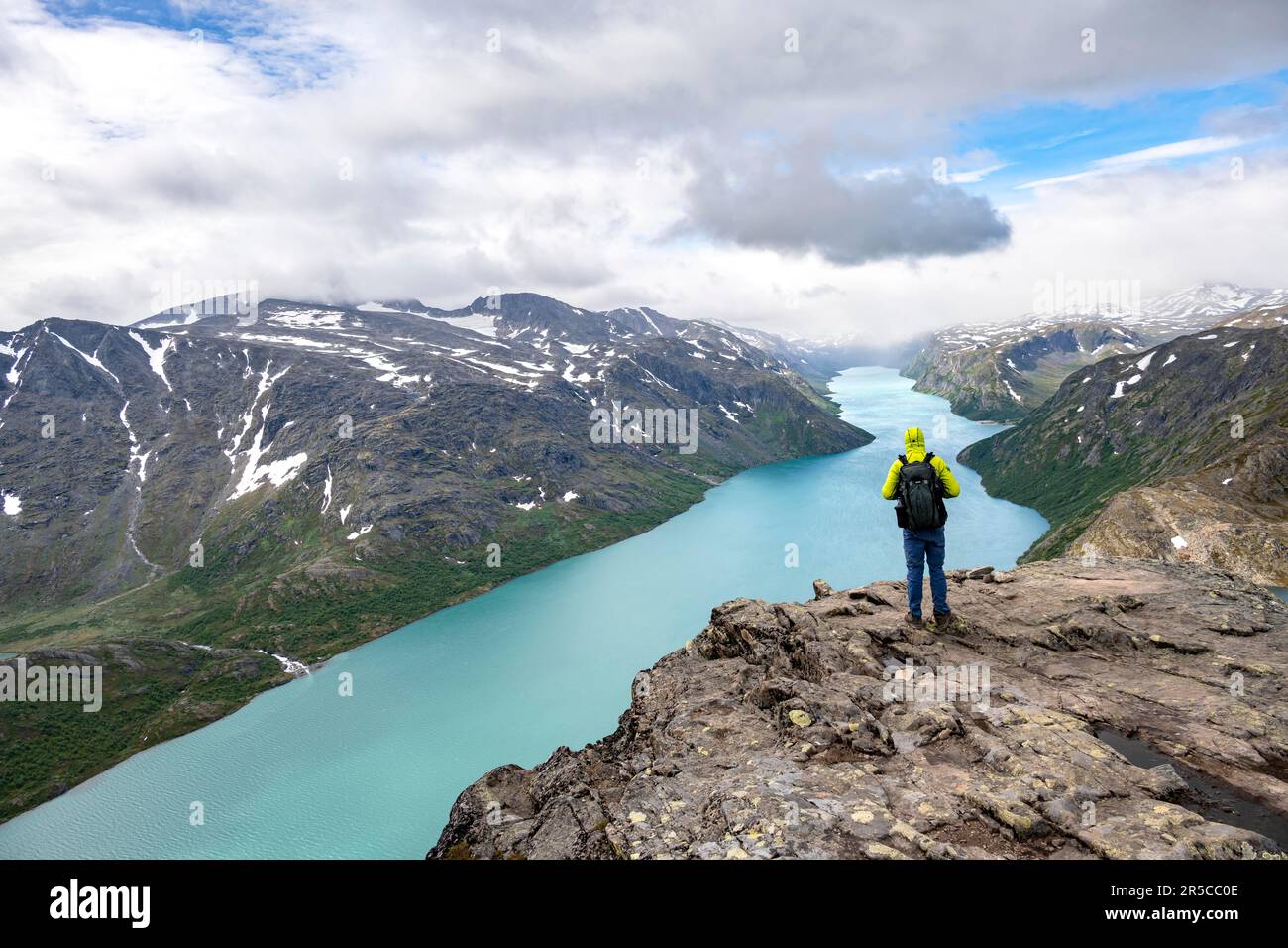 Alpinismo, escursione a Besseggen, passeggiata sul crinale, vista sul lago Gjende e sulle montagne innevate, Parco Nazionale di Jotunheimen, Vaga, Innlandet, Norvegia Foto Stock