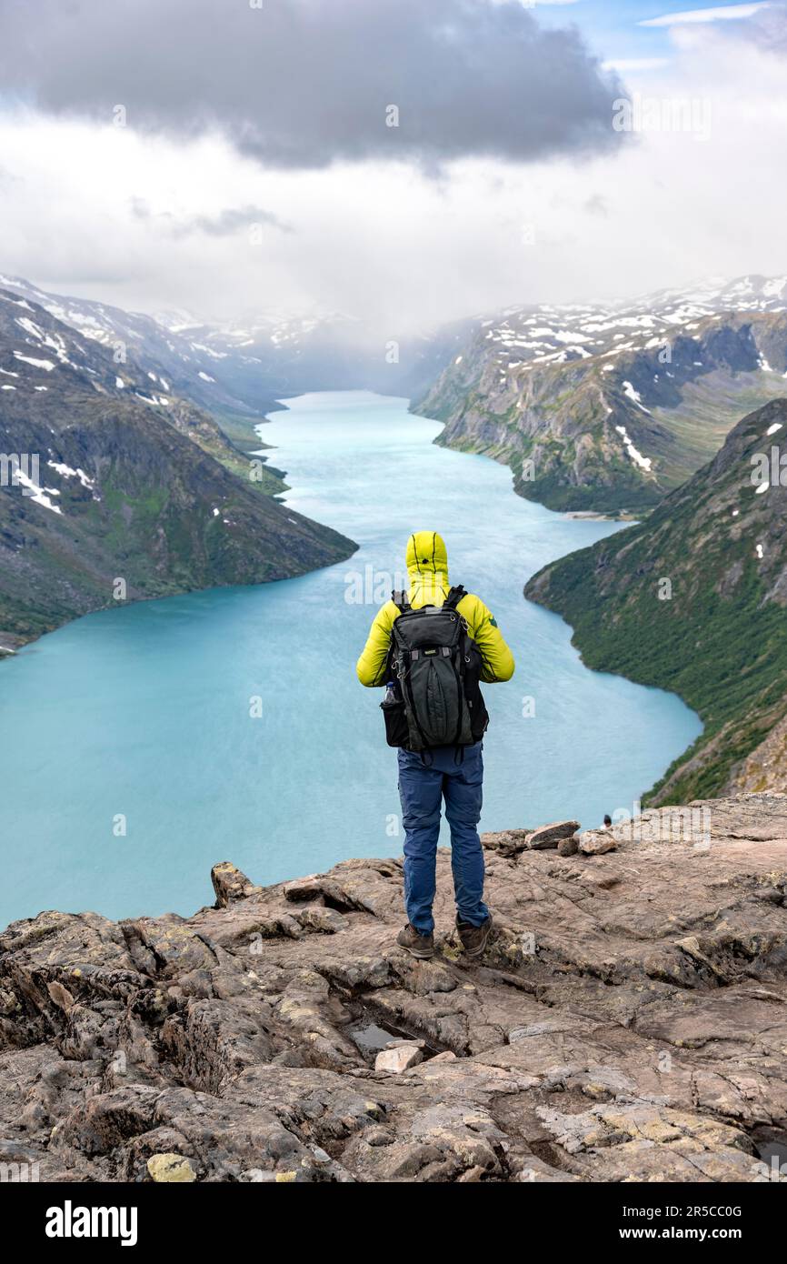 Alpinismo, escursione a Besseggen, passeggiata sul crinale, vista sul lago Gjende e sulle montagne innevate, Parco Nazionale di Jotunheimen, Vaga, Innlandet, Norvegia Foto Stock