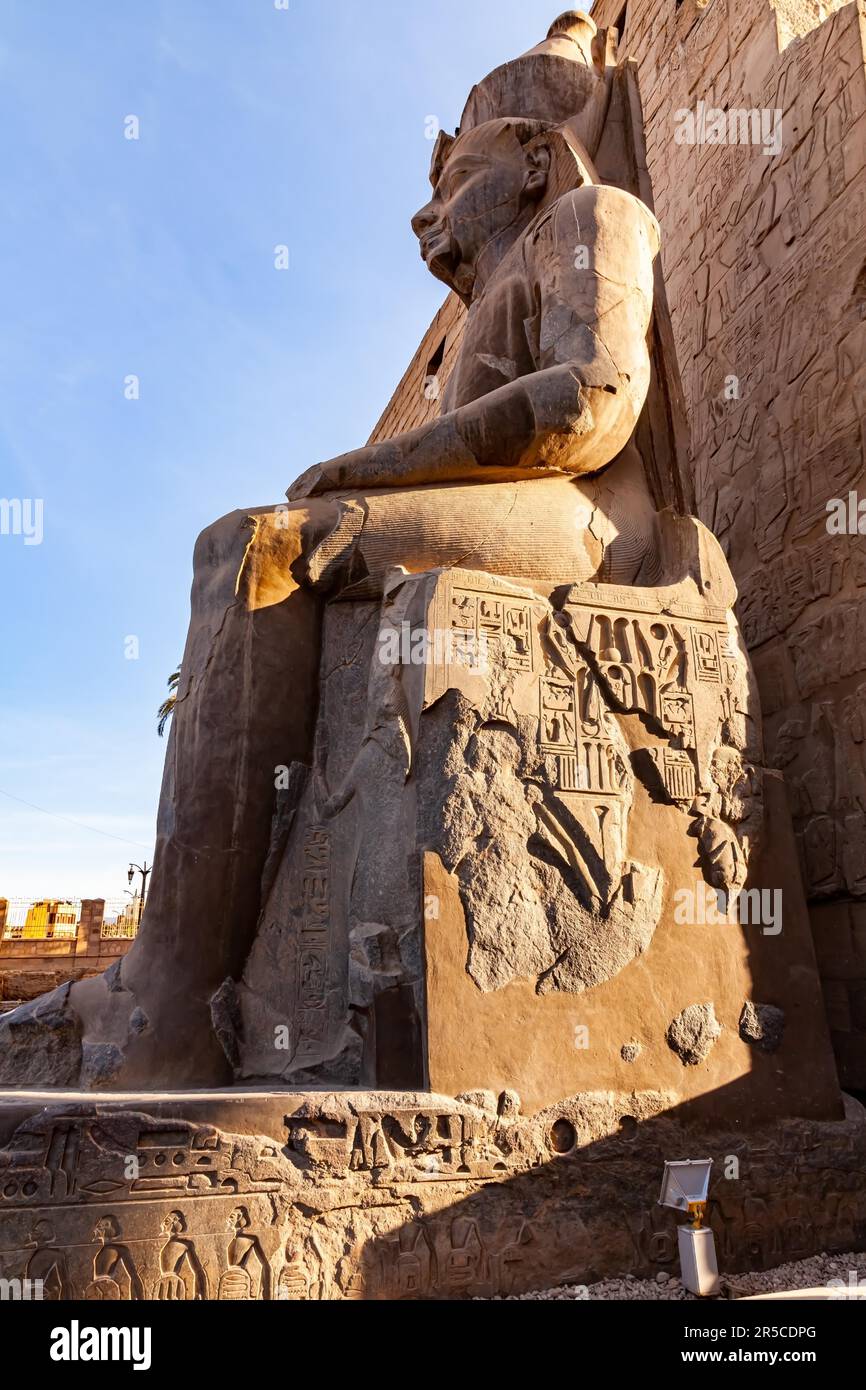 Vista mattutina ad angolo basso della statua del faraone Ramses II di fronte al pilone del complesso del tempio di Luxor a Luxor, Egitto Foto Stock