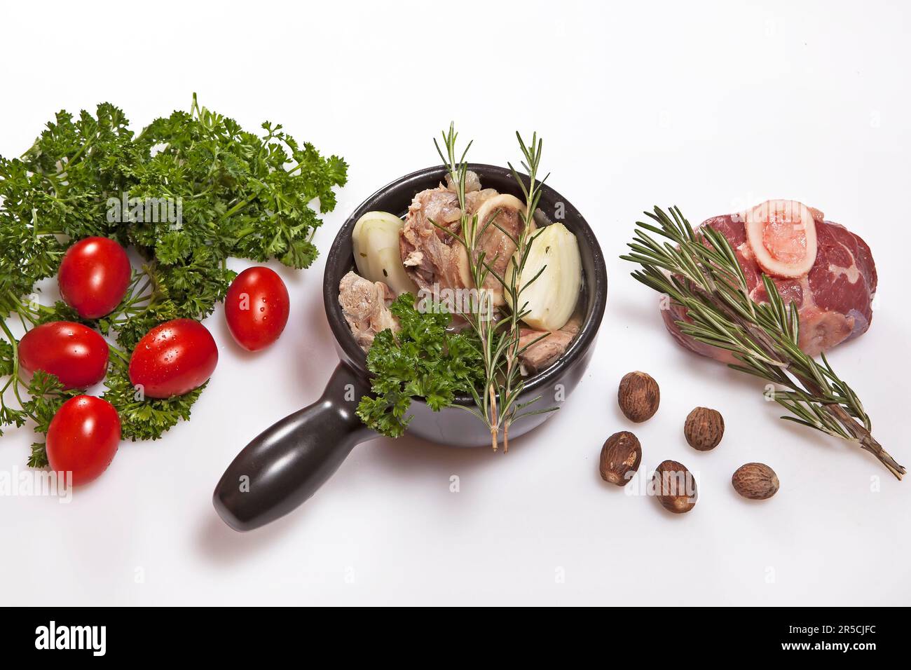 Ingredienti per brodo di manzo fresco, rosmarino, prezzemolo, pomodori, noce moscata, manzo, fetta di coscia, brodo di manzo, zuppa di manzo, carne di zuppa, tazza per zuppa Foto Stock