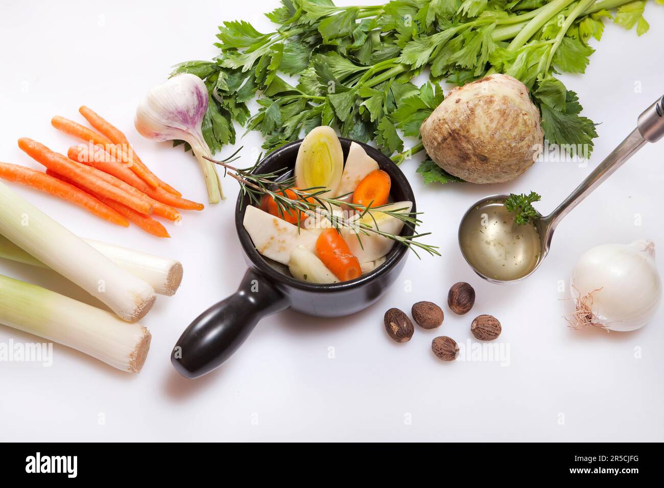 Ingredienti per brodo vegetale fresco vegetariano, porro, carote, aglio, sedano, cipolle, noce moscata, rosmarino, brodo vegetale, tazza per zuppa, carote Foto Stock