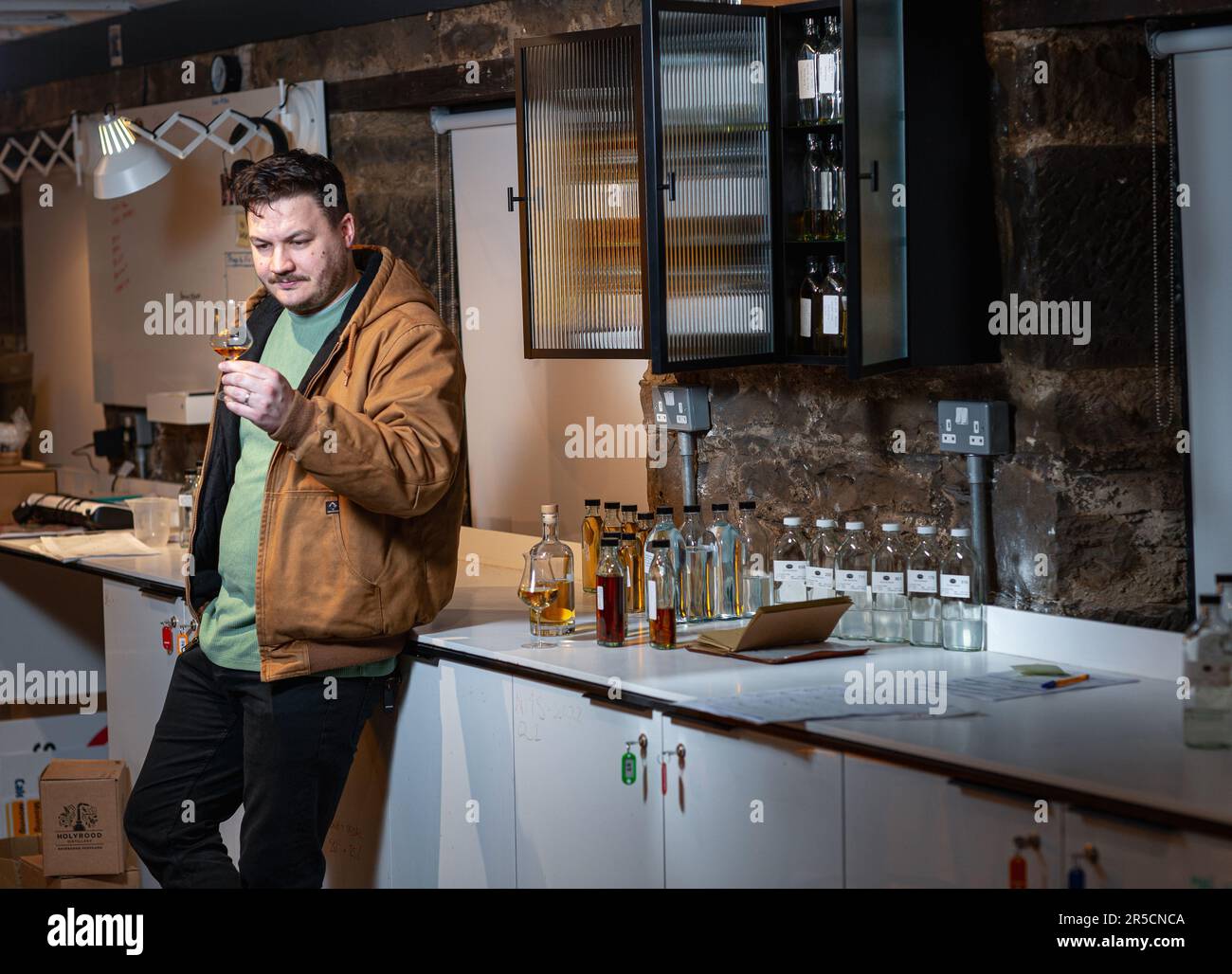 Un uomo assaggia il whisky scozzese presso la distilleria Holyrood di Edimburgo, Scozia Foto Stock