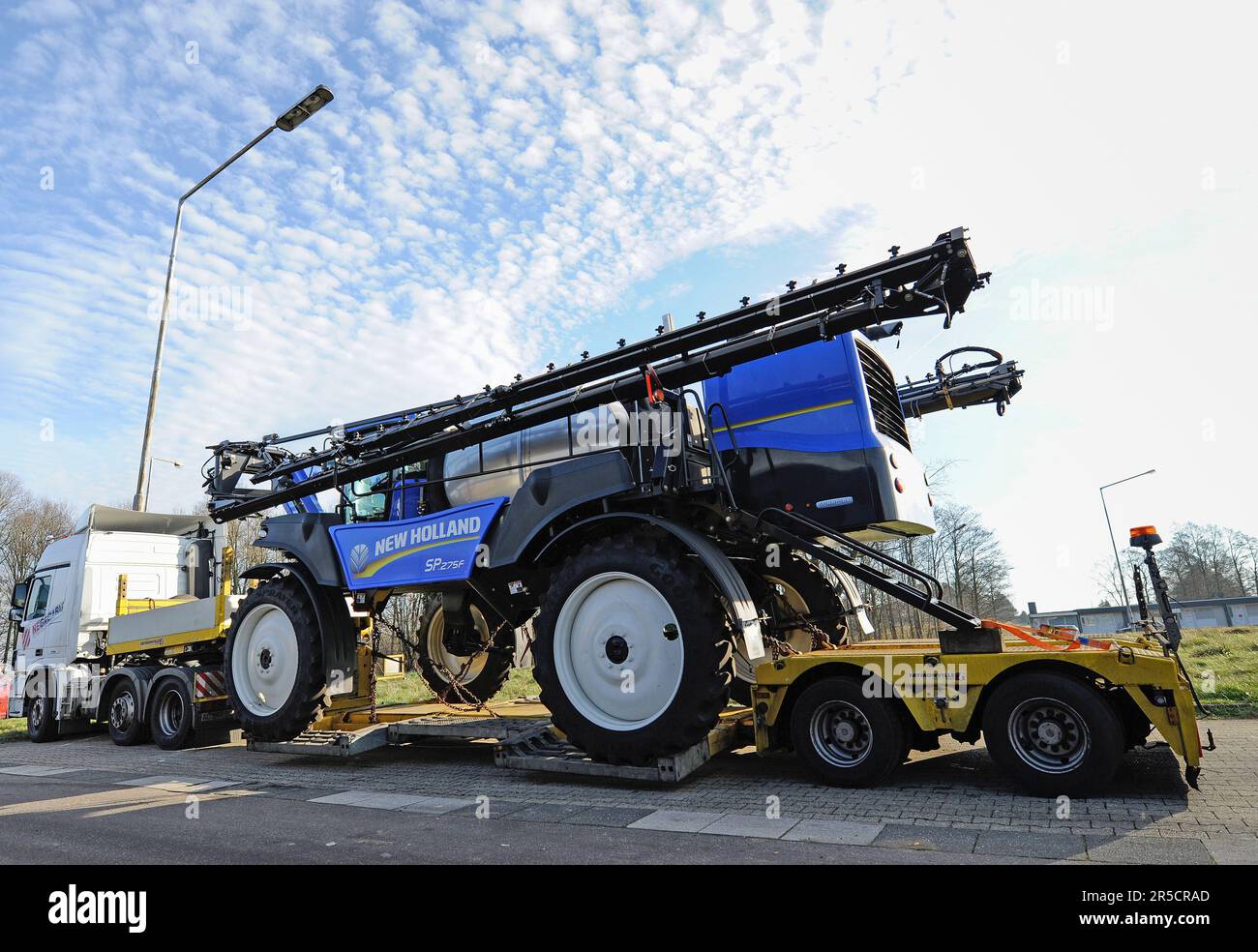 LICHTENB.S., Belgio - 10 dicembre 2016: anteriori del braccio irroratrice agricola, trasportati su una speciale basso-caricatore camion con rimorchio Foto Stock