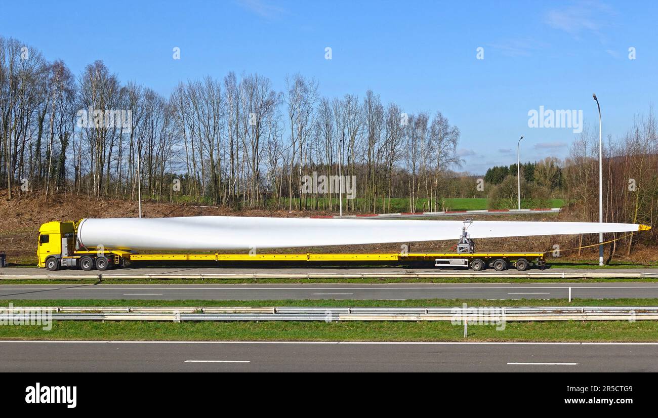 Parcheggio a bordo strada camion speciale con carico di grandi dimensioni che trasporta una pala del rotore per turbine di centrali eoliche Foto Stock