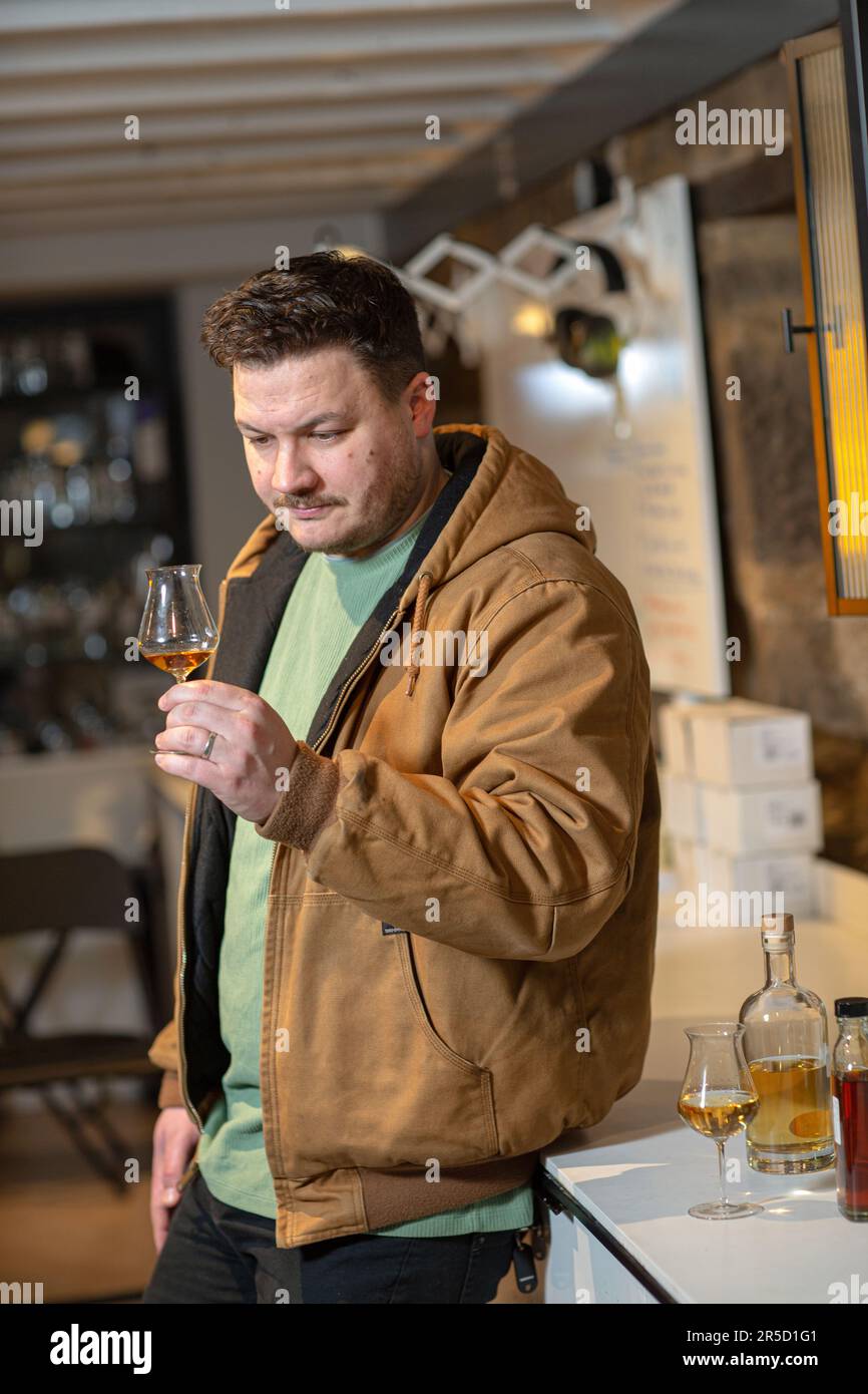 Un uomo assaggia il whisky scozzese presso la distilleria Holyrood di Edimburgo, Scozia Foto Stock
