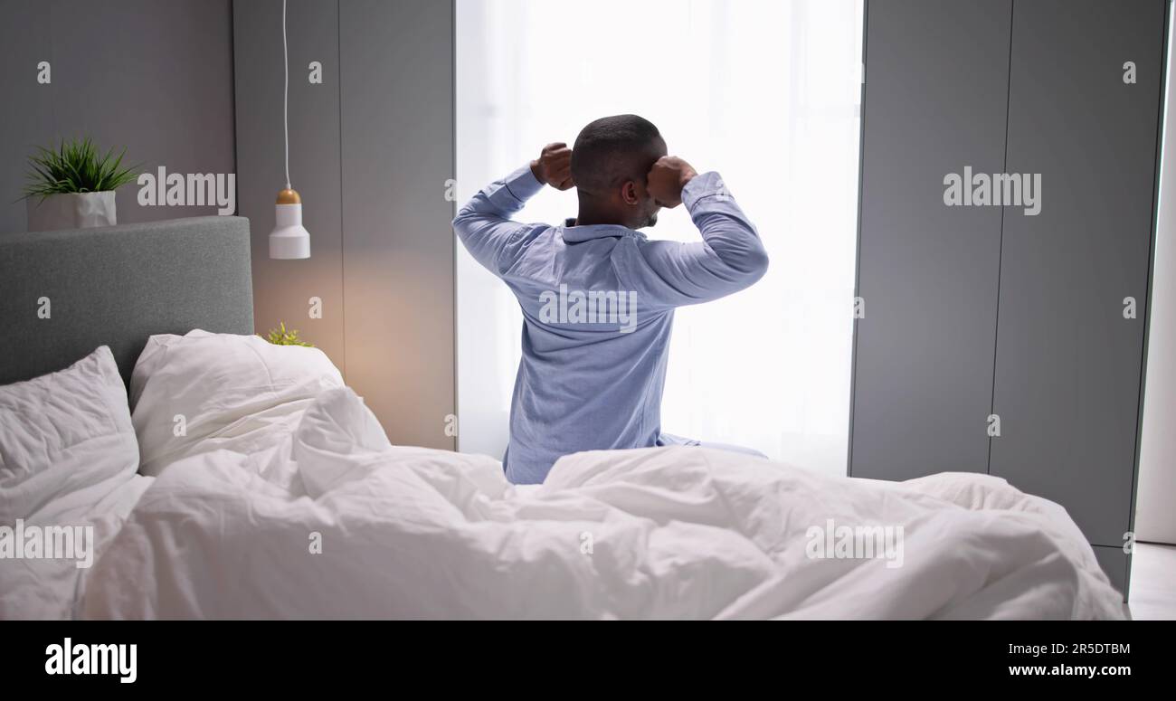 Giovani Sorridenti Africano di svegliarvi in camera da letto Foto Stock