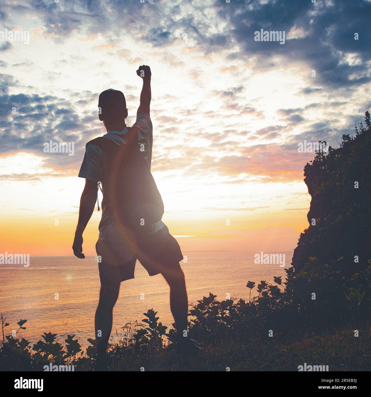 L'uomo che alza i pugni sul cielo del tramonto. La vittoria e il trionfo della gente. Foto Stock