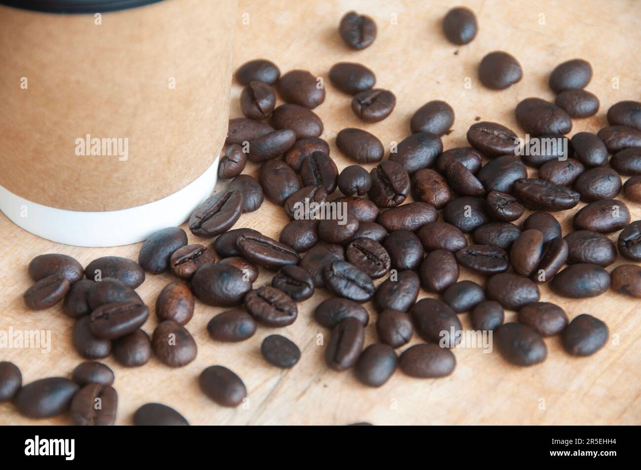 Tazza da asporto circondata da chicchi di caffè con spazio personalizzabile per il testo. Concetto di spazio e caffè. Foto Stock