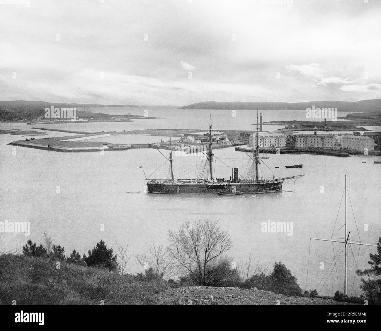 Una vista di fine 19th secolo della navigazione nel porto di Cork, nella contea di Cork, Irlanda. All'epoca era chiamata Queenstown, ma in seguito rinominata Cobh. L'insenatura fu fortificata con il deposito di Haulbowline Navel sulla destra e oltre Spike Island. Un terminal dedicato per le navi da crociera, Cobh è stato il punto di partenza per 2,5 milioni dei sei milioni di irlandesi emigrati in Nord America tra il 1848 e il 1950. Foto Stock