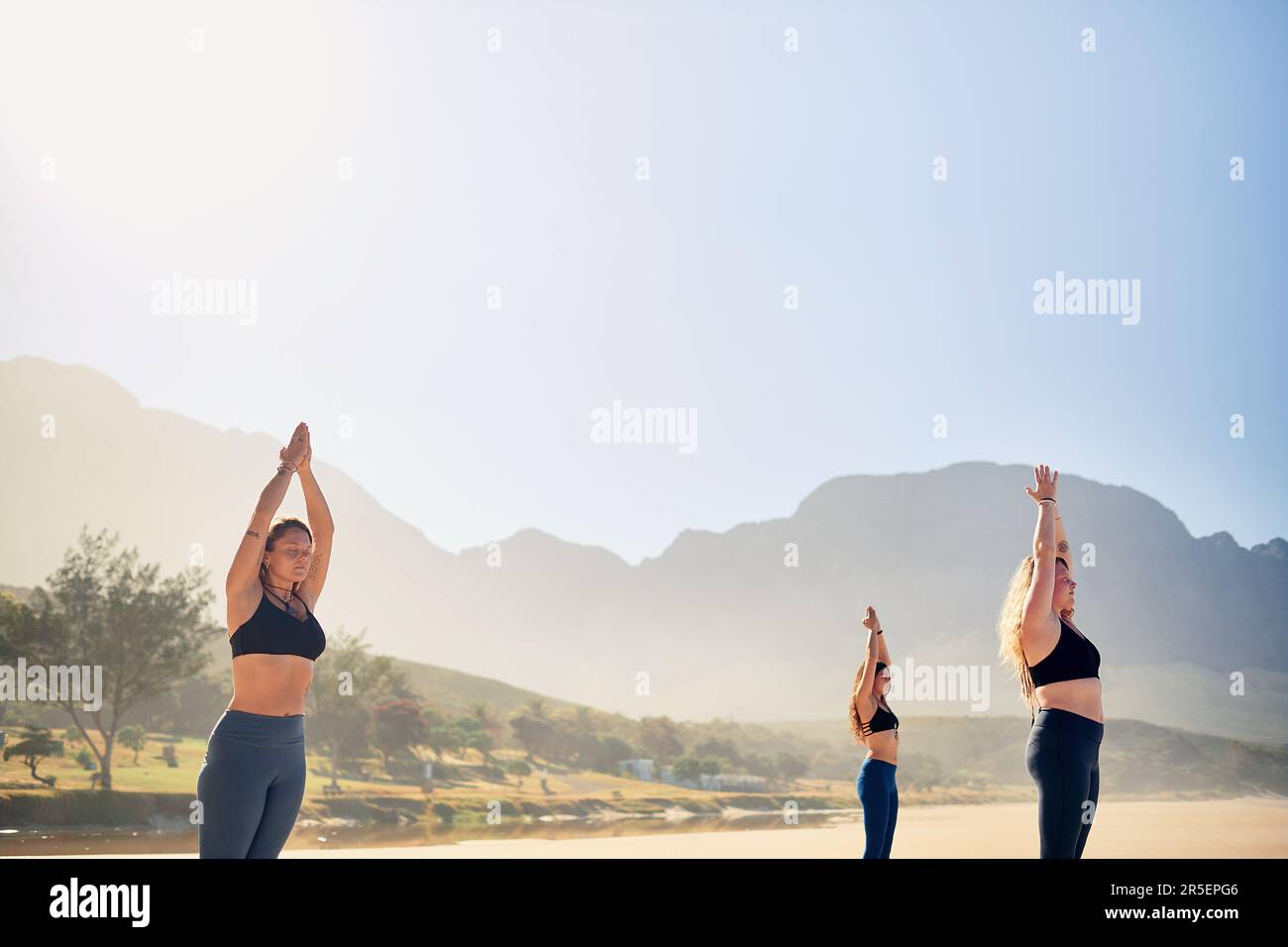 Le piccole cose che vi aiutano a crescere. tre giovani donne che praticano lo yoga sulla spiaggia. Foto Stock