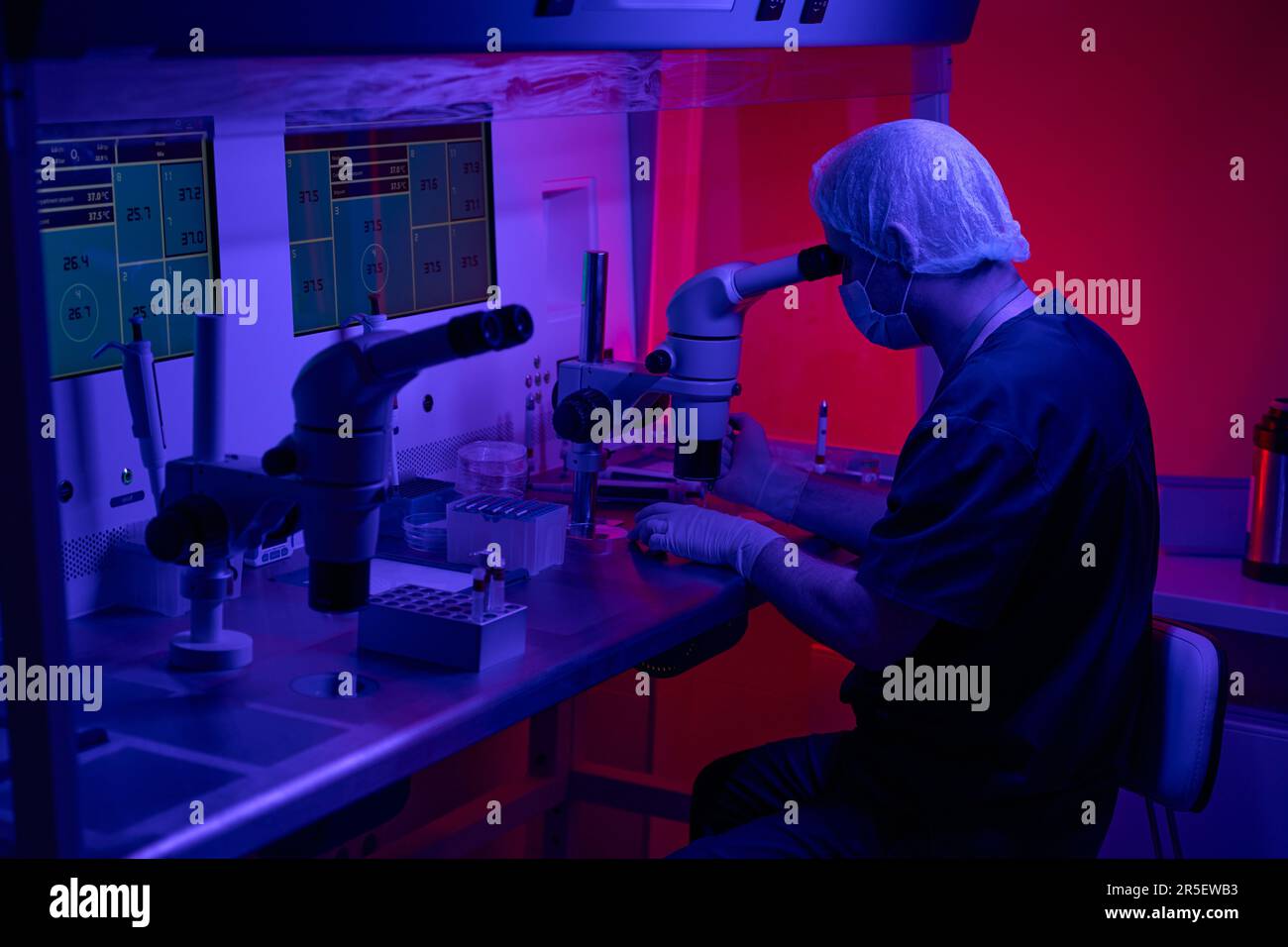 Lavoratore biolaboratorio al suo posto di lavoro in clinica Foto Stock