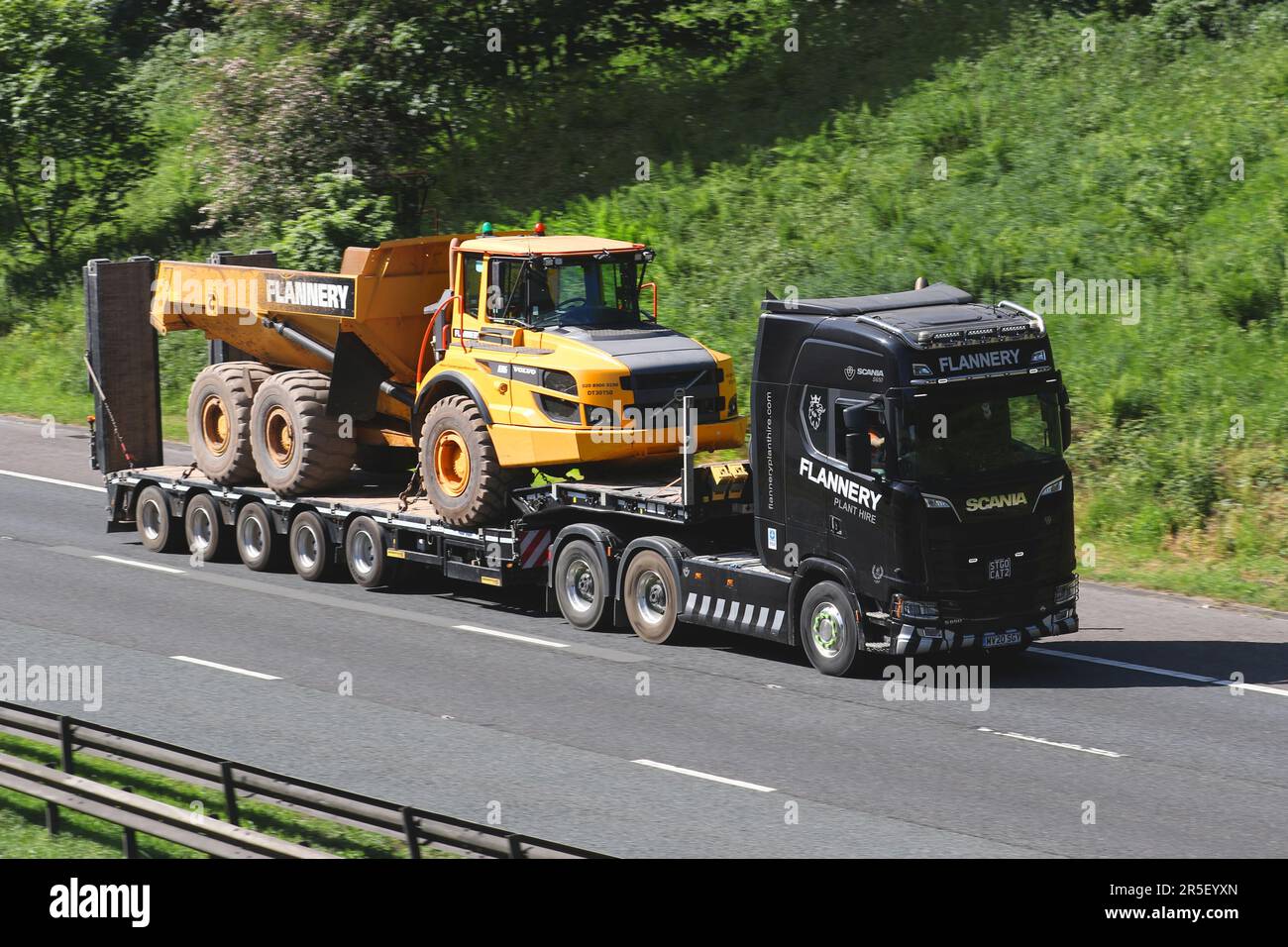 P. FLANNERY PLANT HIRE (OVAL) LIMITED; Scania Low-loader che trasporta grandi Volvo Dumper, Volvo Un autocarro 30 G che viaggia sull'autostrada M61 UK Foto Stock