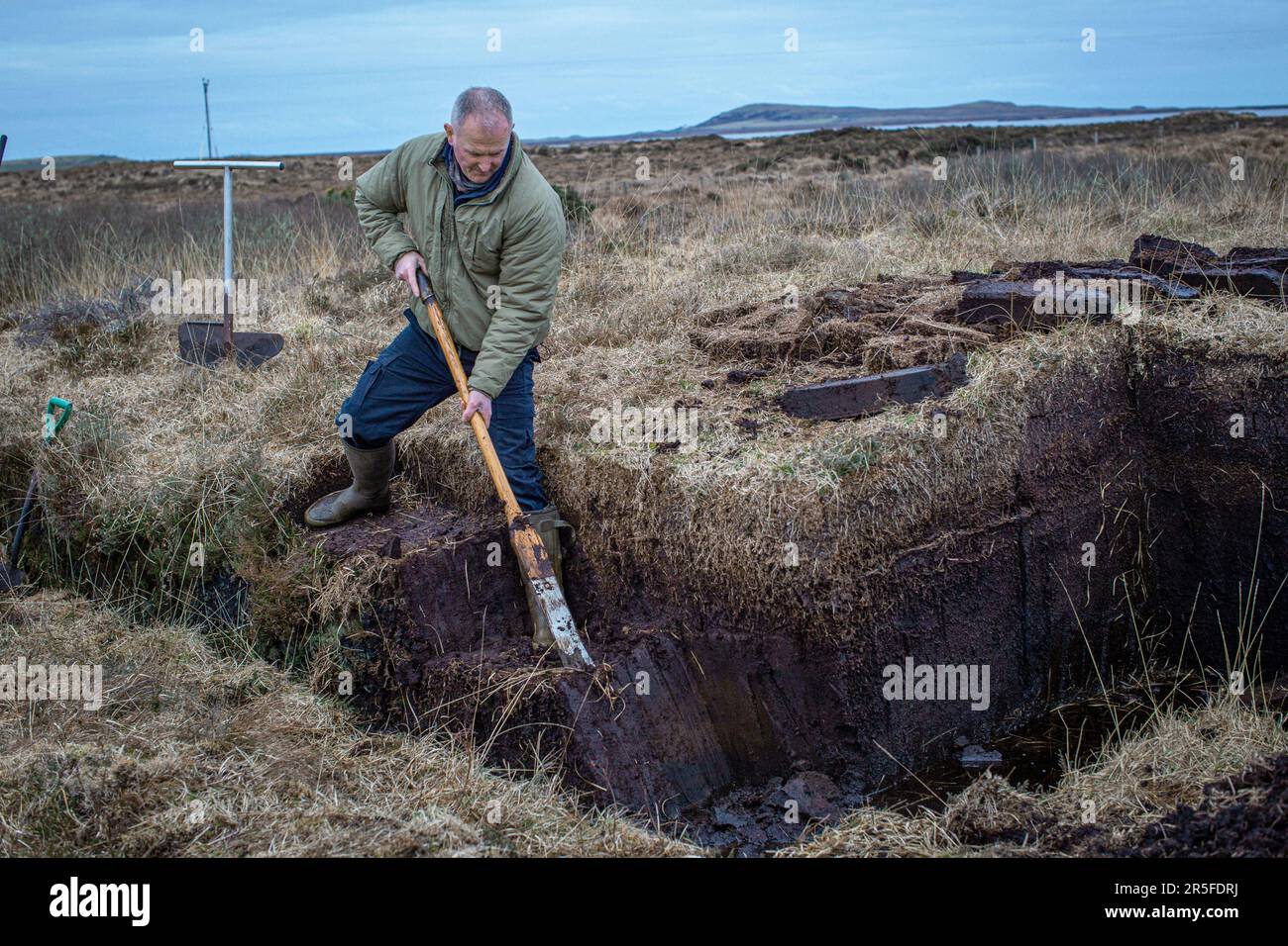 Cesoia per torba al lavoro sulle rive del Loch Gorm a Islay, Scozia Foto Stock