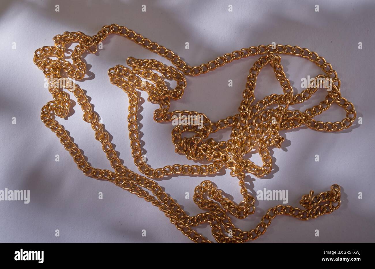 collana in oro sul pavimento bianco Foto Stock