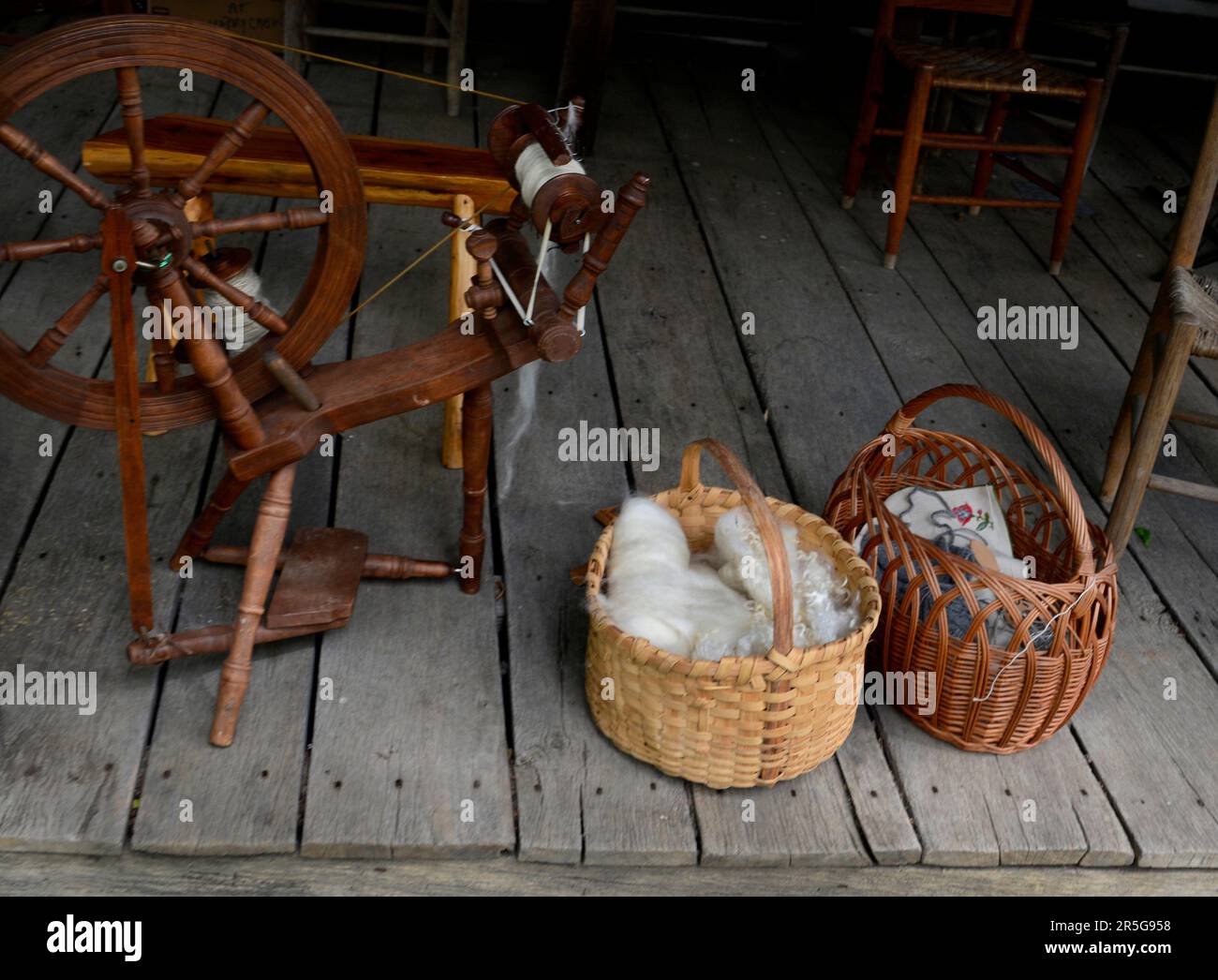 Cesti di lana cardata e altri tessuti sul portico del 19th ° secolo in legno cabina durante un evento di rievocazione storia vivente a Abingdon, Virginia. Foto Stock