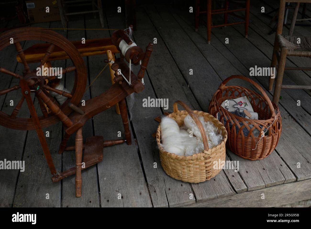 Cesti di lana cardata e altri tessuti sul portico del 19th ° secolo in legno cabina durante un evento di rievocazione storia vivente a Abingdon, Virginia. Foto Stock