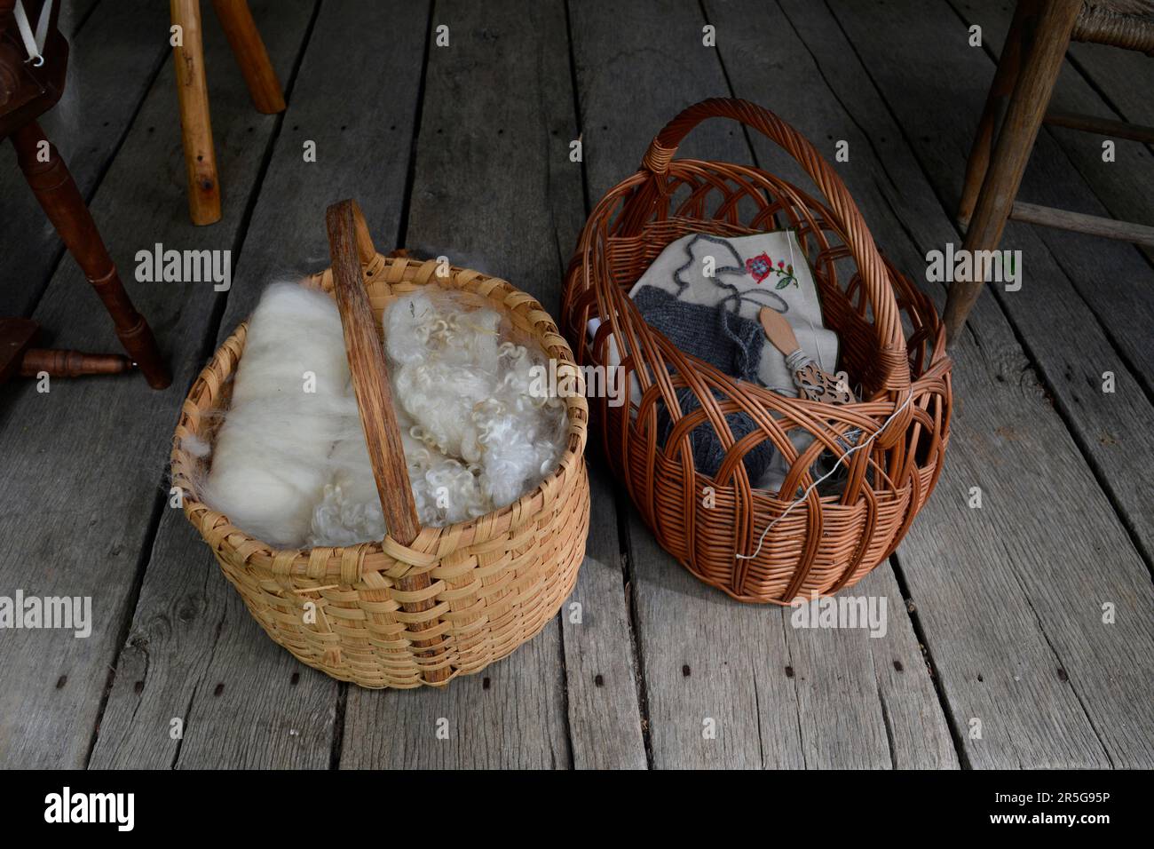 Cesti di lana cardata e altri tessuti sul portico del 19th ° secolo in legno cabina durante un evento di rievocazione storia vivente a Abingdon, Virginia. Foto Stock